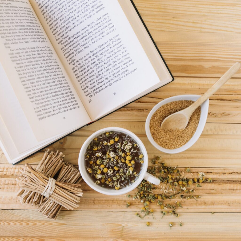 te-de-manzanilla-y-azucar-moreno-cerca-del-libro
